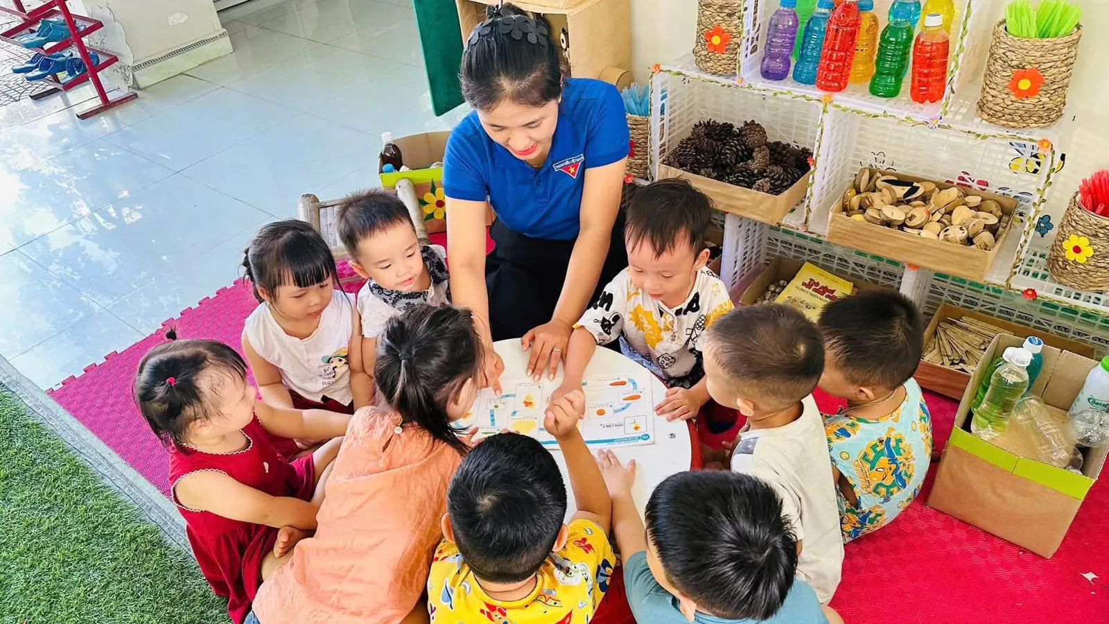 Cô giáo hướng dẫn trẻ trong hoạt động nhóm